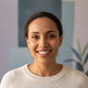Authentic headshot portrait of a happy, diverse woman smiling, suggesting satisfaction and trust.